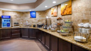 A hotel breakfast area with a self-service buffet, a coffee machine, and a large wheat-themed painting on the wall. - Comfort Suites North Dallas (Dallas)