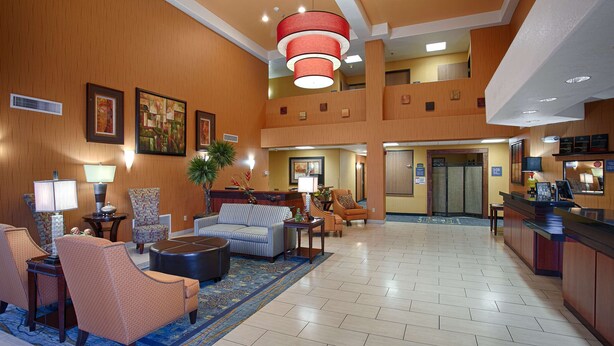 A spacious lobby with a high ceiling, a reception desk, and a seating area with sofas and armchairs. - Best Western Plus Fresno Inn (Fresno)