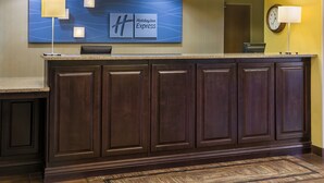 Ein dunkler Holztresen, eine blaue Wand mit dem Holiday Inn Express Logo und eine Wanduhr.