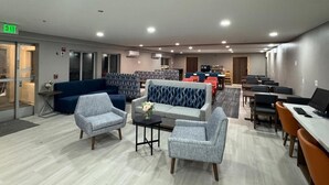 Un hall de hotel con zonas de estar, mostrador de recepción y una sala de conferencias.