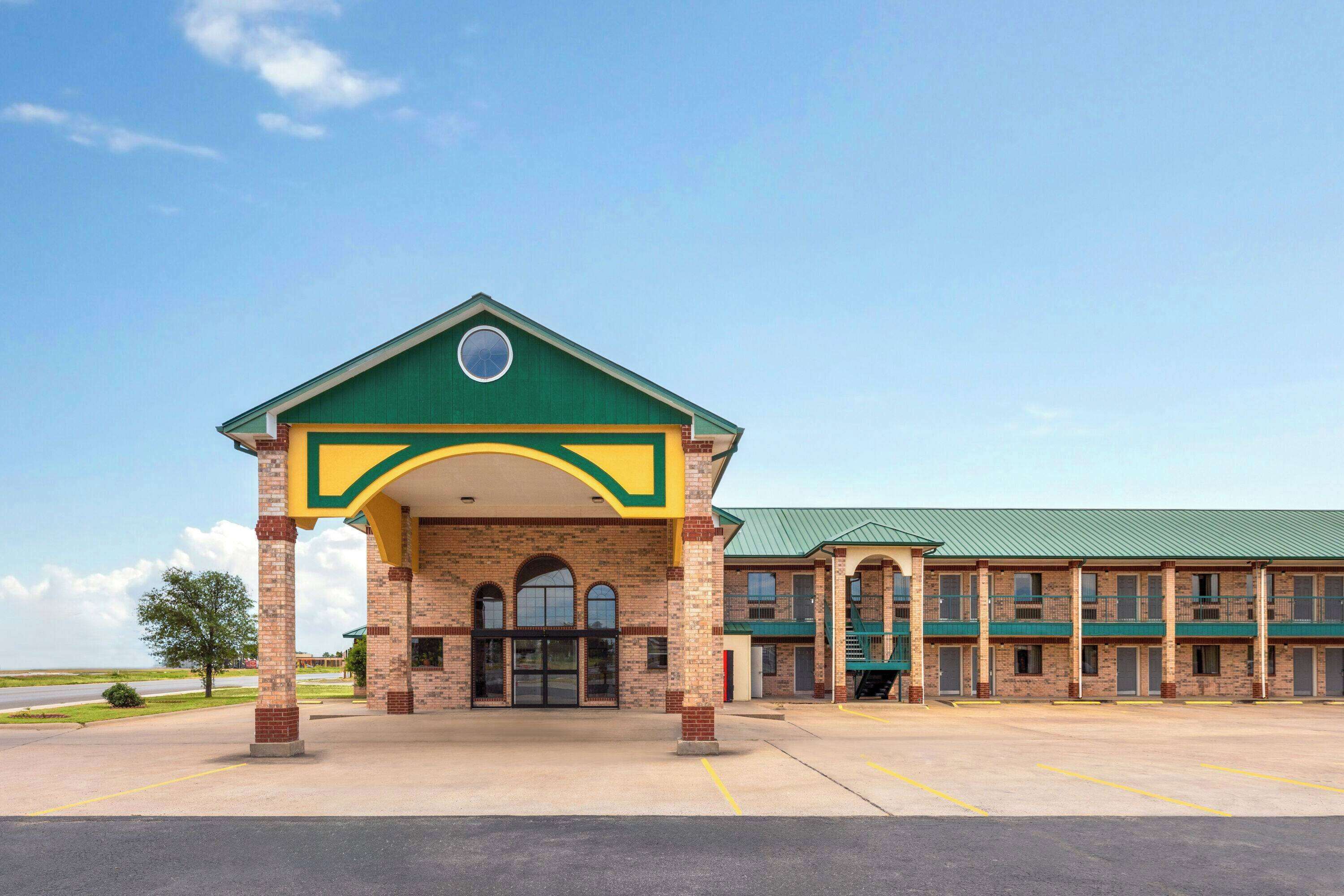 A two-story building with a green roof and a covered entrance area.