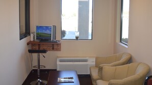 Une pièce comprenant un bureau, un ordinateur, une chaise et une fenêtre.