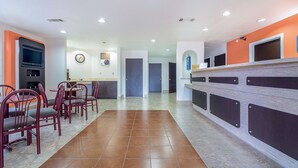 A modern kitchen with a central island, built-in appliances, and a dining area with red chairs. - Motel 6 Canton, TX (Canton)