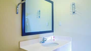 A bathroom with a white sink, a mirror, and a towel rack.
