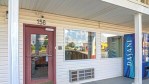 A building with a red door, a number 156 sign above it, and a blue sign with the text "DASANI" on the right. - Economy Inn Ashburn GA I-75 (Ashburn)