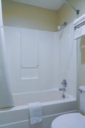 A standard bathroom with a bathtub, toilet, and a towel rack. - Economy Inn by OYO Ashburn I-75 (Ashburn)