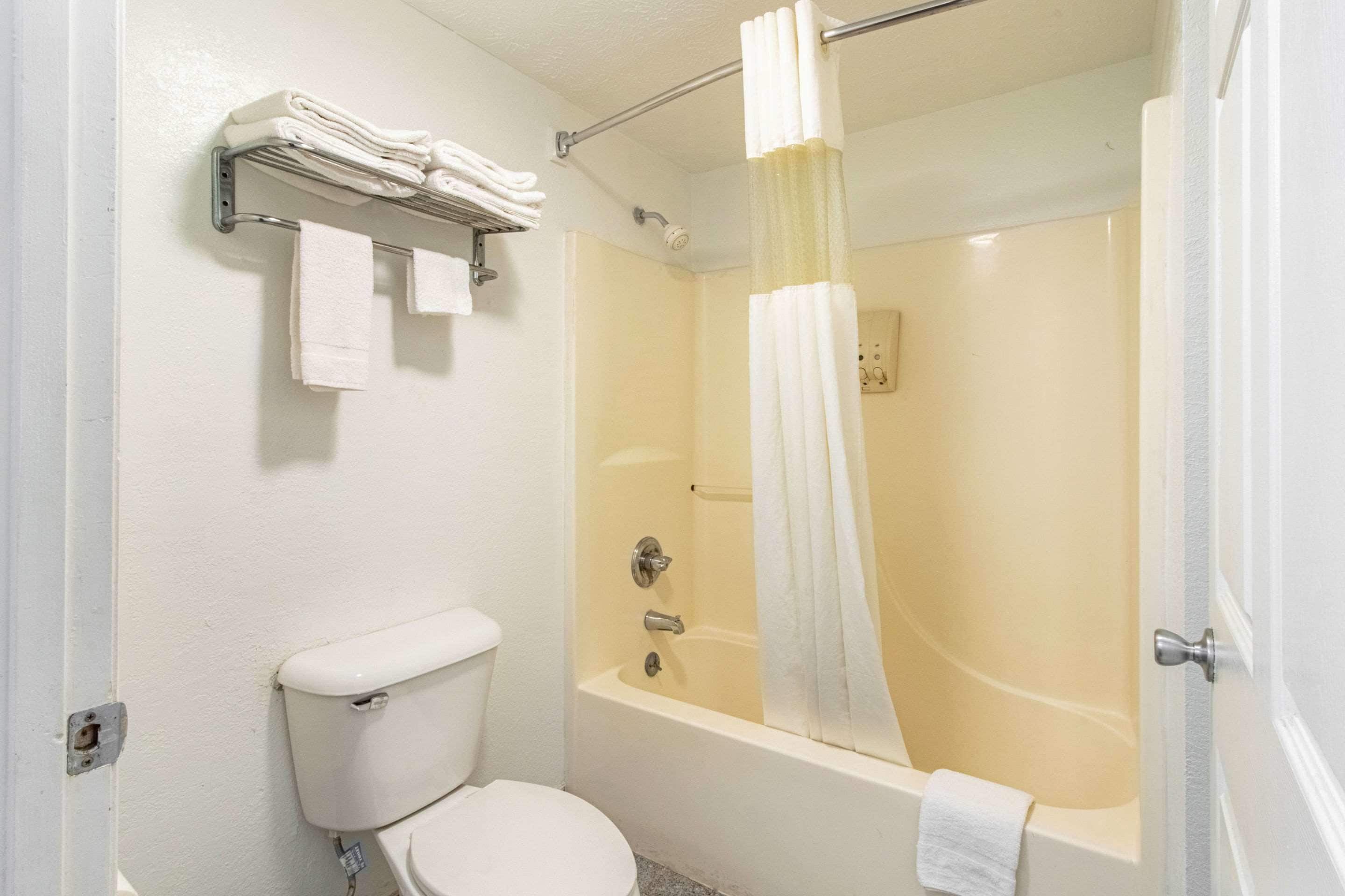 Un baño con inodoro, bañera y cortina de ducha.