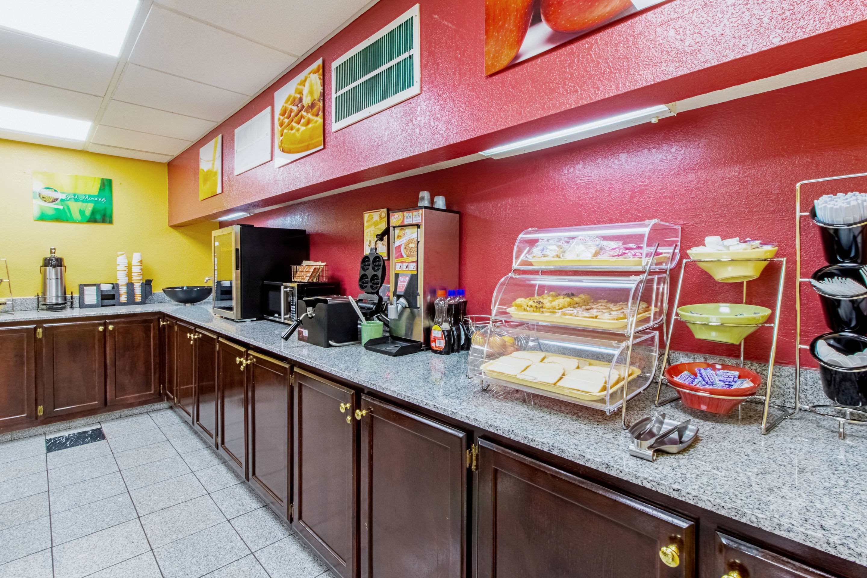 A breakfast bar with various food items and appliances.