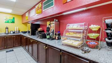 A breakfast bar with various food items and appliances.