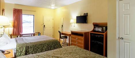 A hotel room with two beds, a desk, a chair, a television, a microwave, and a door.
