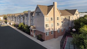 A multi-story hotel with a prominent 'Resilience Inn' sign, a basketball court, and a parking lot.