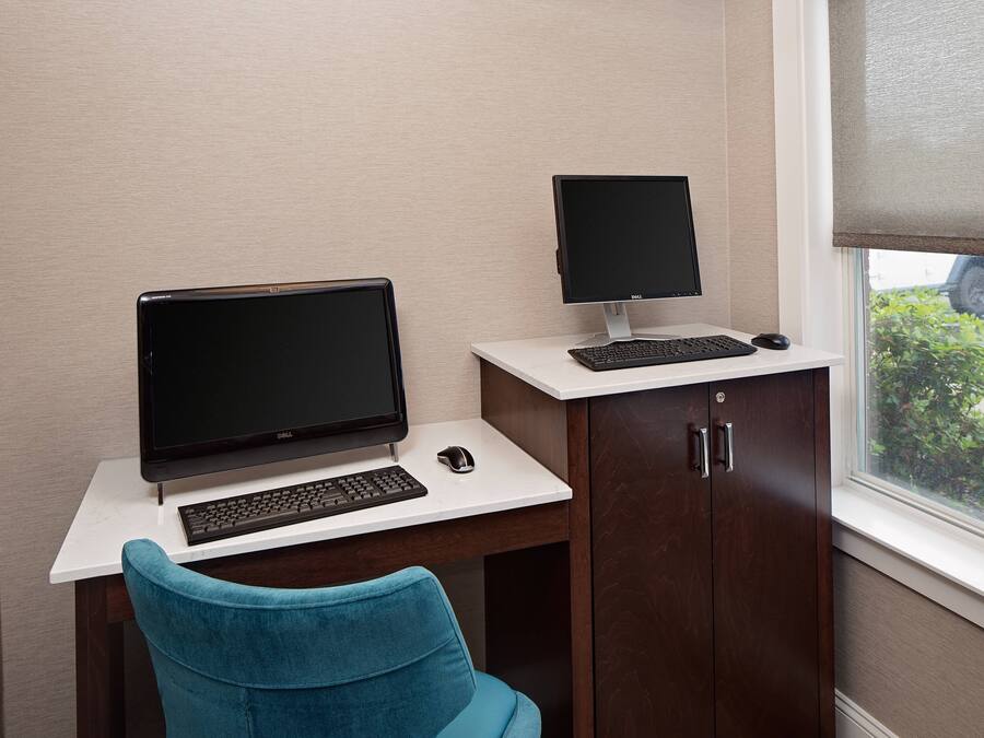 A workspace with a desk, two monitors, a keyboard, and a mouse.
