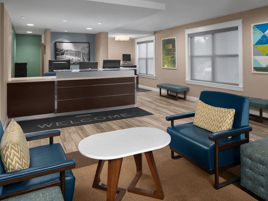 A modern lobby with a reception desk, seating area, and artwork on the walls.