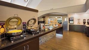 A buffet setup with various food stations, including scrambled eggs, chicken, and hot & fresh options.