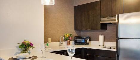 A modern kitchen with a central island, stainless steel appliances, and a pendant light.