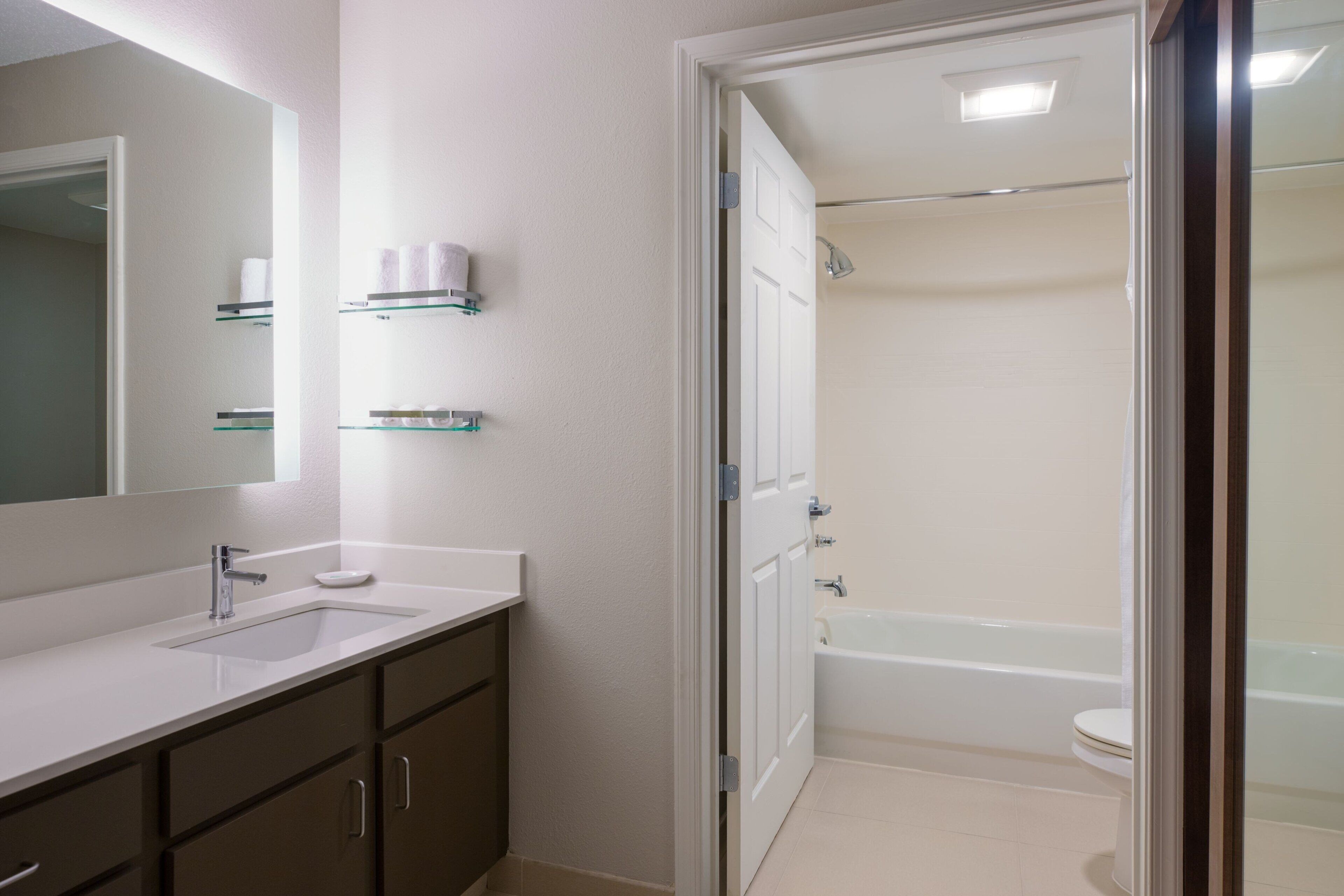 Une salle de bain équipée d’un lavabo, d’un miroir et d’un espace douche.