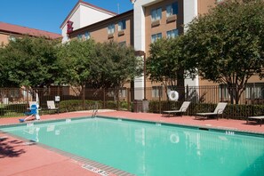 Una piscina al aire libre, sombrillas, tumbonas