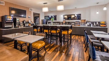 Restaurante moderno com piso de madeira, banquetas no balcão e espaço para café.