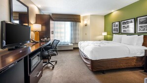 A hotel room with a bed, desk, TV, and a large window with curtains. - Sleep Inn Henderson-Evansville South (Henderson)