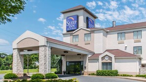 A Sleep Inn hotel with a modern design, featuring a covered entrance and a prominent signage.
