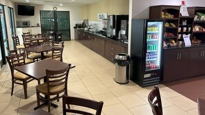 Un restaurante con mostrador, zona de estar y un refrigerador lleno de bebidas.