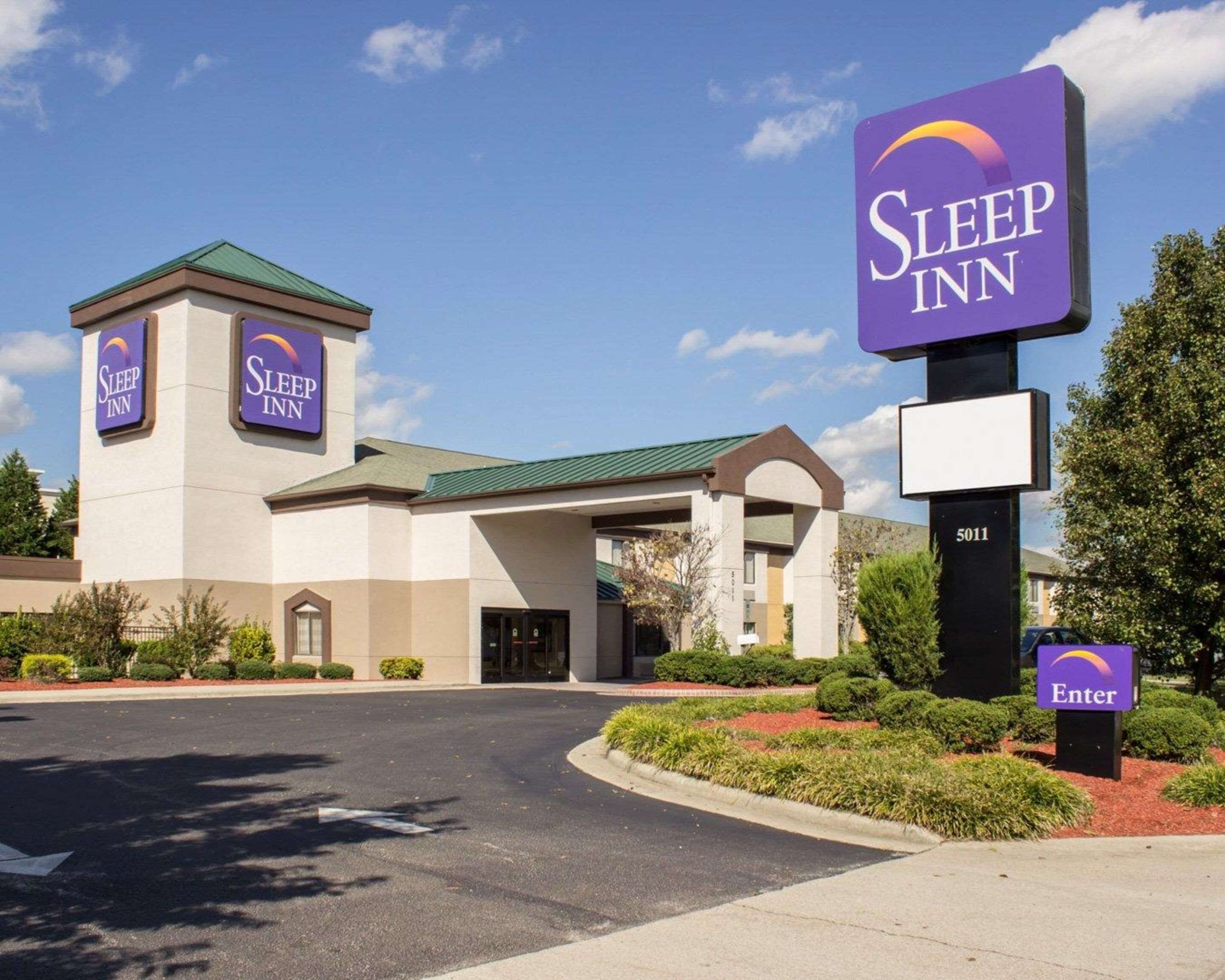 Un hotel Sleep Inn con un diseño moderno, que presenta una entrada destacada y un cartel con el número 5011.