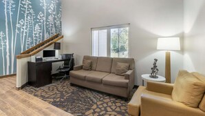 A living room with a sofa, a desk, a computer, and a lamp. - Sleep Inn Mt. Pleasant - Charleston (Mount Pleasant)