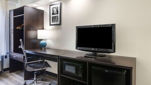 A modern hotel room with a desk, a flat-screen TV, a microwave, and a wardrobe. - Sleep Inn Mt. Pleasant - Charleston (Mount Pleasant)