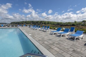 Una piscina al aire libre de temporada, sombrillas