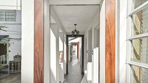 A narrow hallway with wooden door frames and a ceiling light fixture. - Chesterfield Hotel & Suites (Miami Beach)