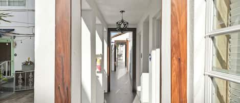 A narrow hallway with wooden door frames and a ceiling light fixture.