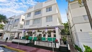 A white building with the name "Cesterfield" on the facade, featuring a balcony with green seating and potted plants. - Chesterfield Hotel & Suites (Miami Beach)