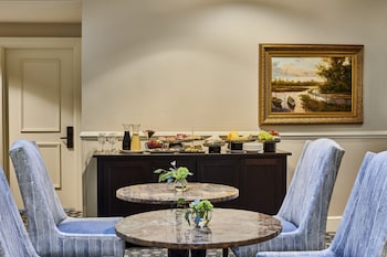 A conference room with a long table, chairs, and a screen displaying the Harboursview Inn logo. at HarbourView Inn