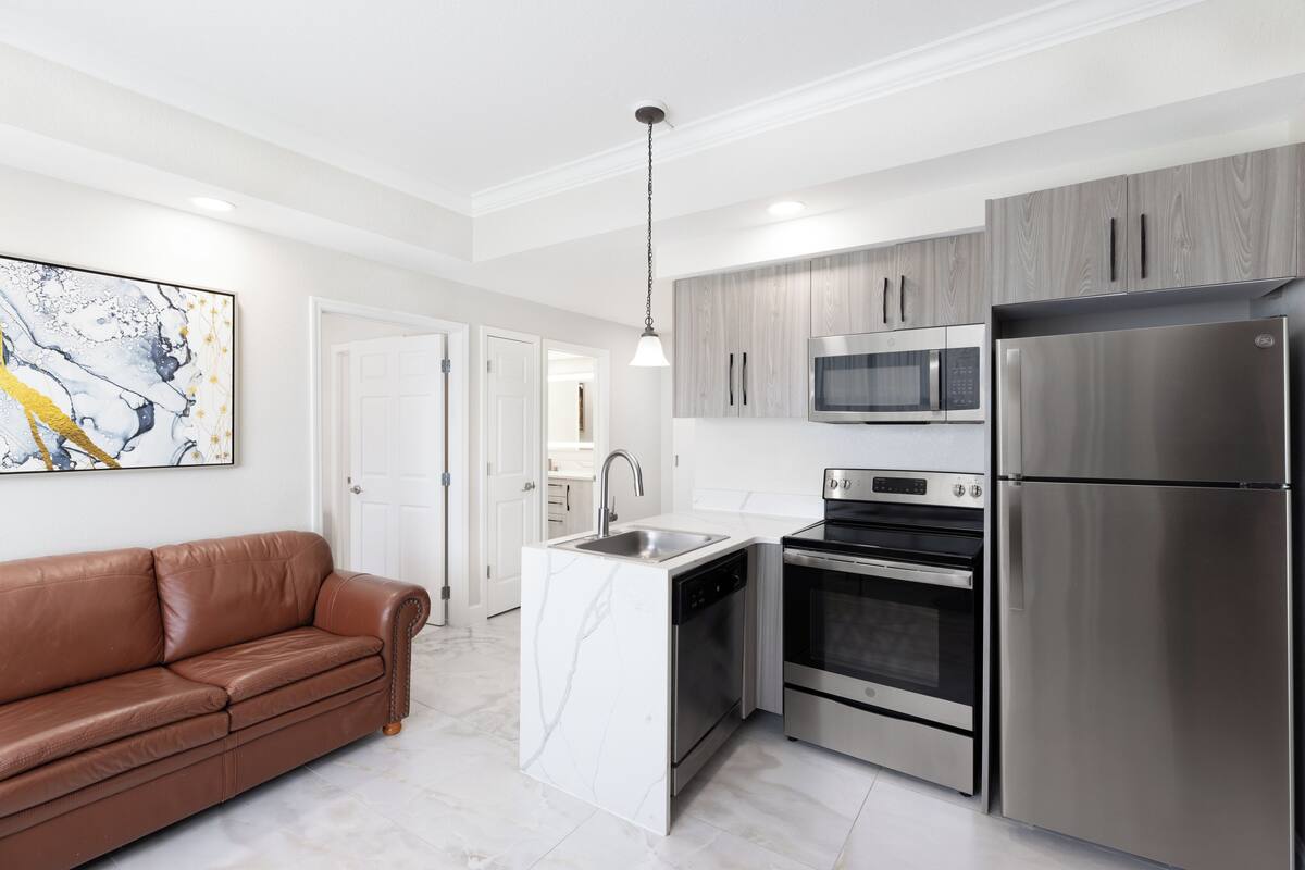 A modern kitchen with stainless steel appliances, a built-in oven, and a microwave.