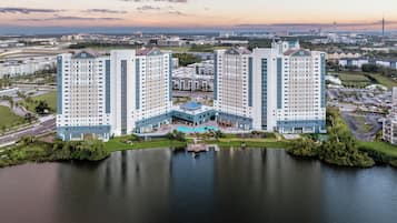 A high-rise hotel with a central courtyard, a swimming pool, and a view of the surrounding cityscape.