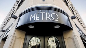 De ingang van Hotel Metro, met een moderne gevel en gebogen ramen.