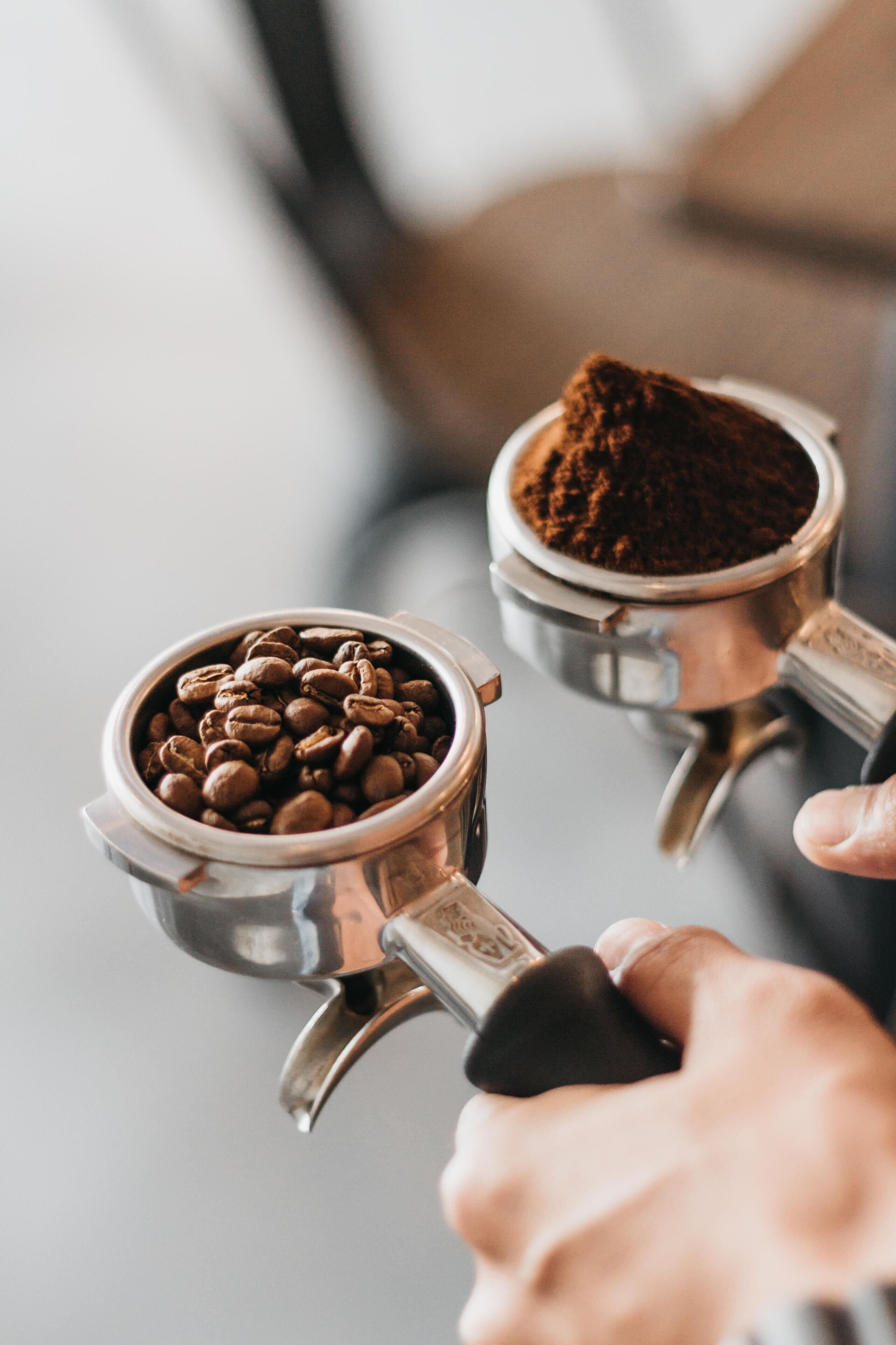 A close-up of a coffee grinder with coffee beans and ground coffee.