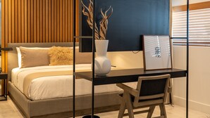 A modern bedroom with a bed, bedside table, chair, and a desk with a chair. - Nassau Suite South Beach, an All-Suite Hotel (Miami Beach)