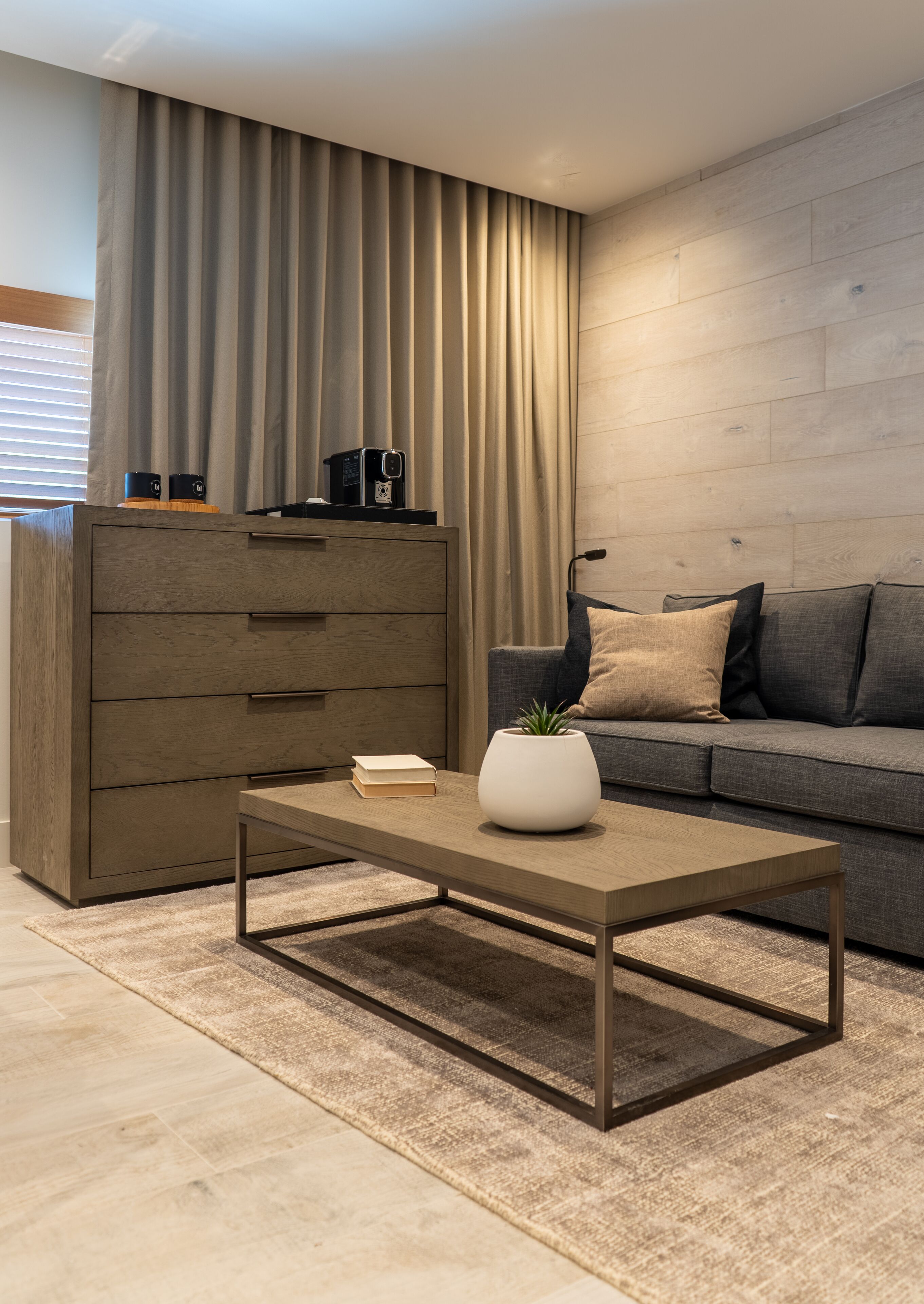 Una sala moderna con una mesa de centro de madera, un sofá y un mueble aparador grande.