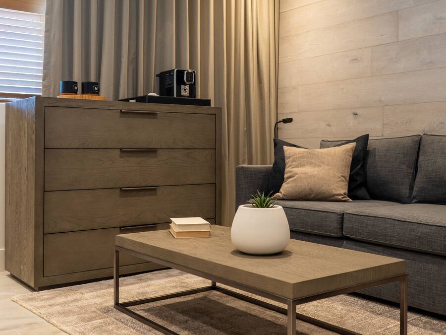 Una sala moderna con una mesa de centro de madera, un sofá y un mueble aparador grande.
