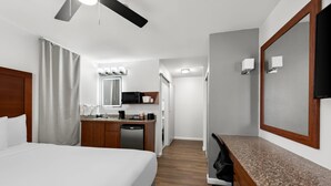 A hotel room with a bed, a desk, a microwave, a coffee maker, and a TV. - Comfort Inn Gaslamp Convention Center (San Diego)