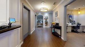 A hotel lobby with a reception desk, a coffee machine, a decorative wall, and a computer desk with a chair. - Comfort Inn Gaslamp Convention Center (San Diego)