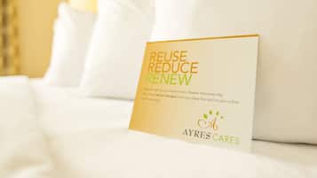 A card on a bed with the text "REUSE REDUCE RENEW" and the logo "AYRES CARES".