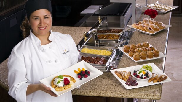 A buffet setup with various food items, including waffles, pastries, and fruits. - Ayres Suites Diamond Bar (Diamond Bar)