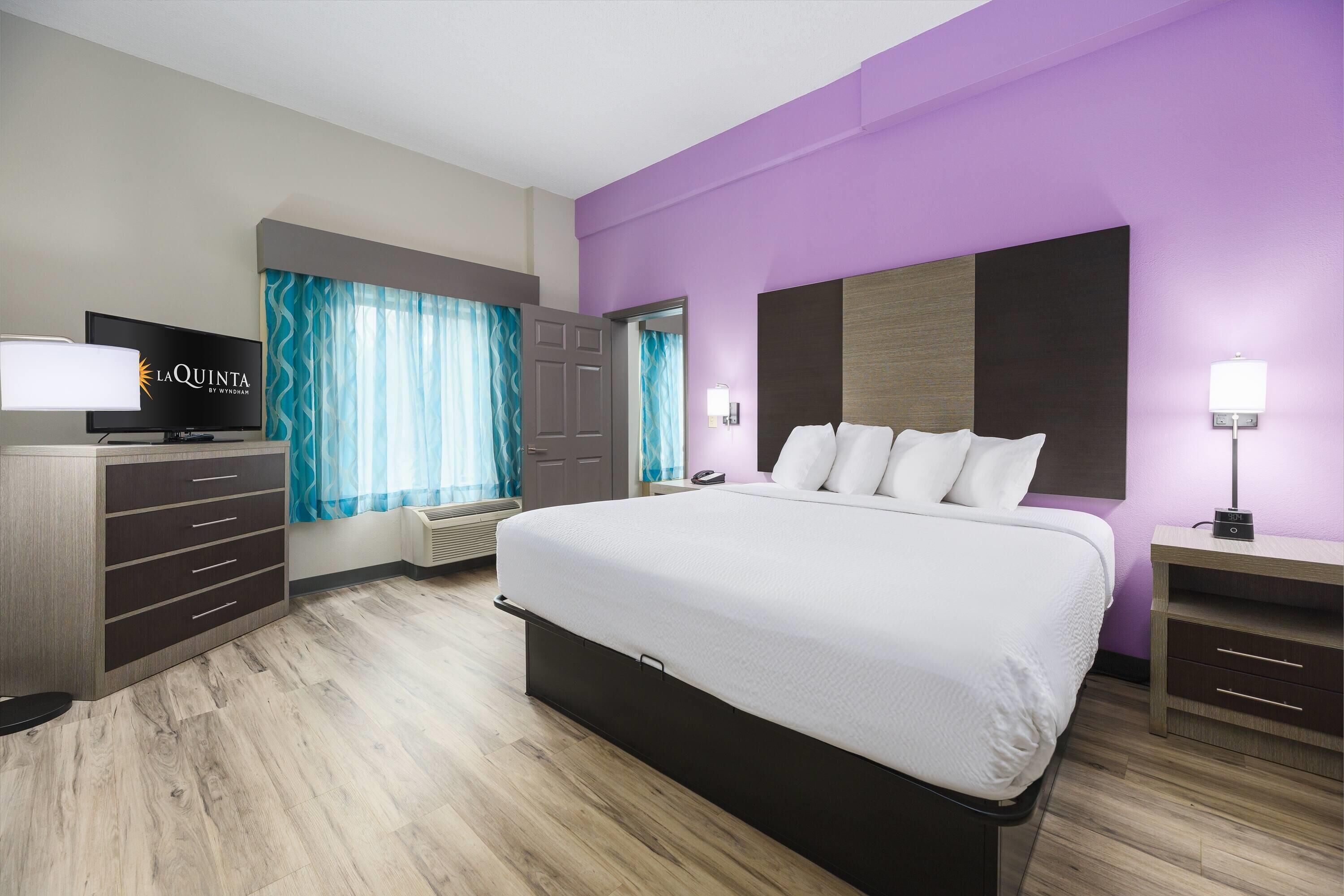 Une chambre d’hôtel équipée d’un lit, d’une télévision, d’un bureau et d’une armoire.