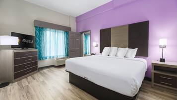 Une chambre d’hôtel équipée d’un lit, d’une télévision, d’un bureau et d’une armoire.