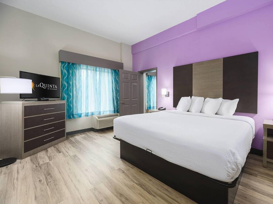 Une chambre d’hôtel équipée d’un lit, d’une télévision, d’un bureau et d’une armoire.