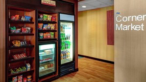 A corner market with shelves stocked with snacks and a refrigerated section. - Fairfield by Marriott Inn & Suites Anniston Oxford (Oxford)