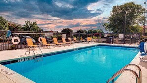 A swimming pool with lounge chairs and a 'No Lifeguard On Duty' sign. - Fairfield by Marriott Inn & Suites Anniston Oxford (Oxford)