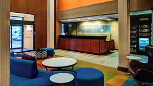 A lobby with seating areas, a reception desk, and a vending machine. - Fairfield by Marriott Inn & Suites Anniston Oxford (Oxford)